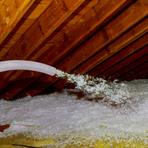 insulation being sprayed onto attic floor